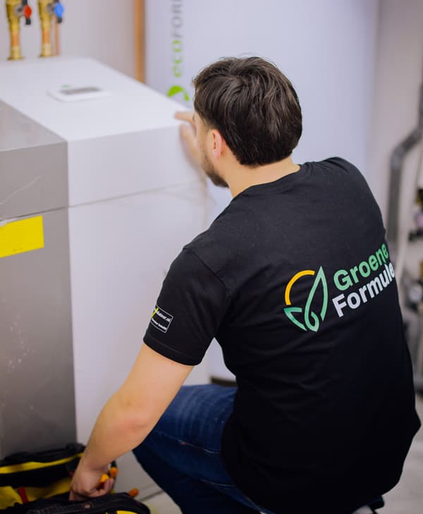 Monteur van Groene Formule werkt aan een boilerunit